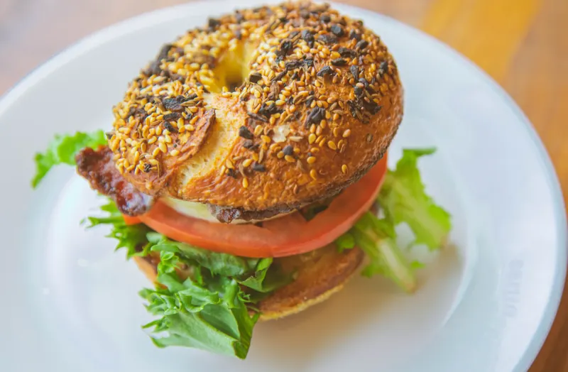 An everything bagel BLT with bacon, lettuce and tomato