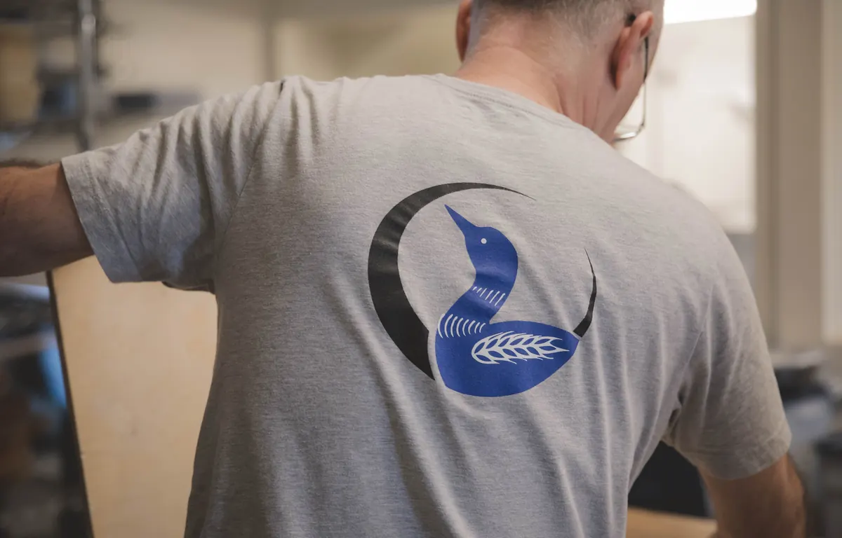 A baker wearing a Blue Loon logo T-shirt at work in the kitchen