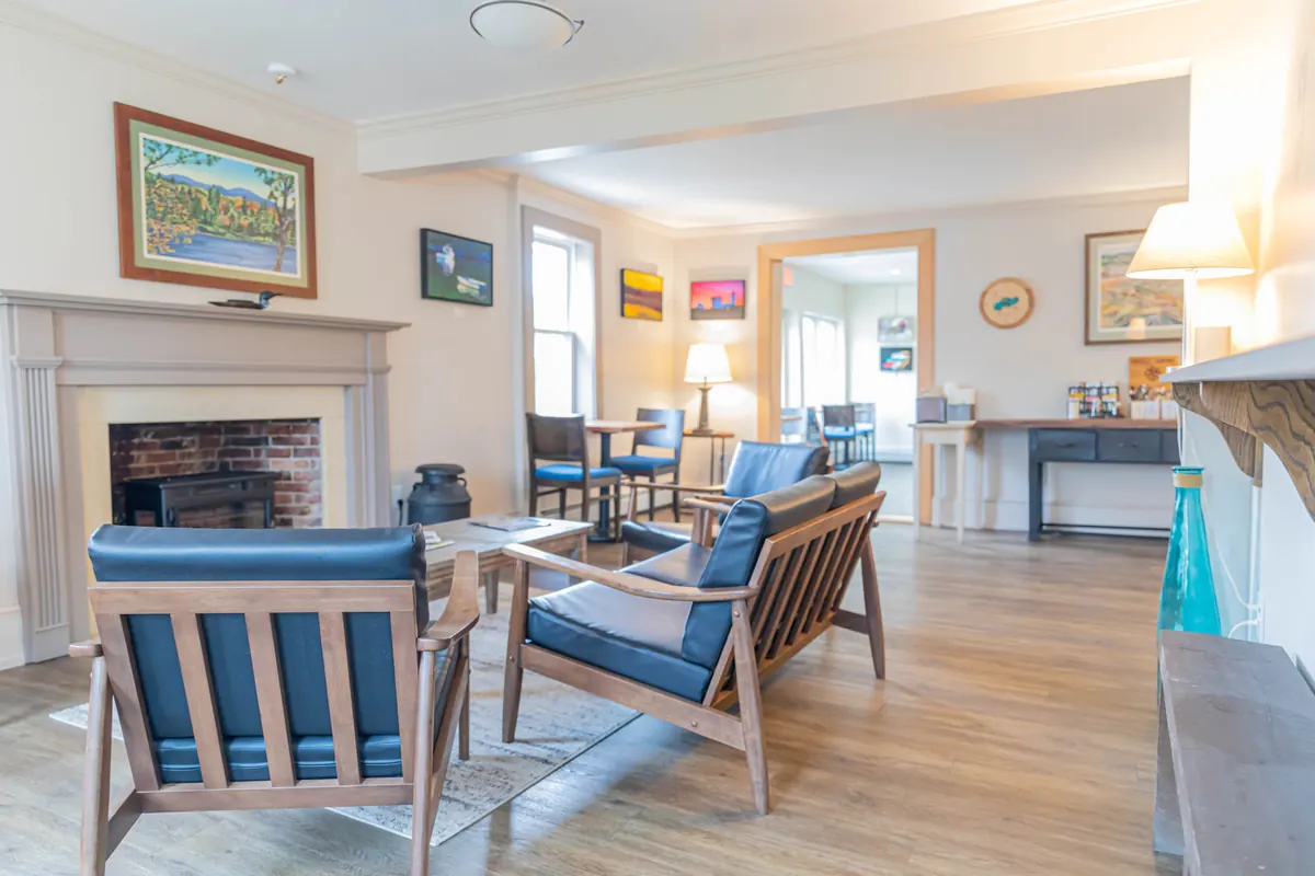 A cozy sitting room with a fireplace and blue wooden armchairs